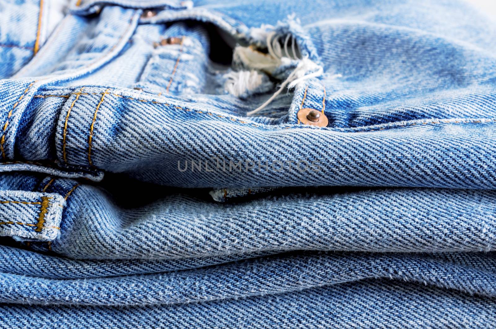 Stack of blue jeans as a background or texture