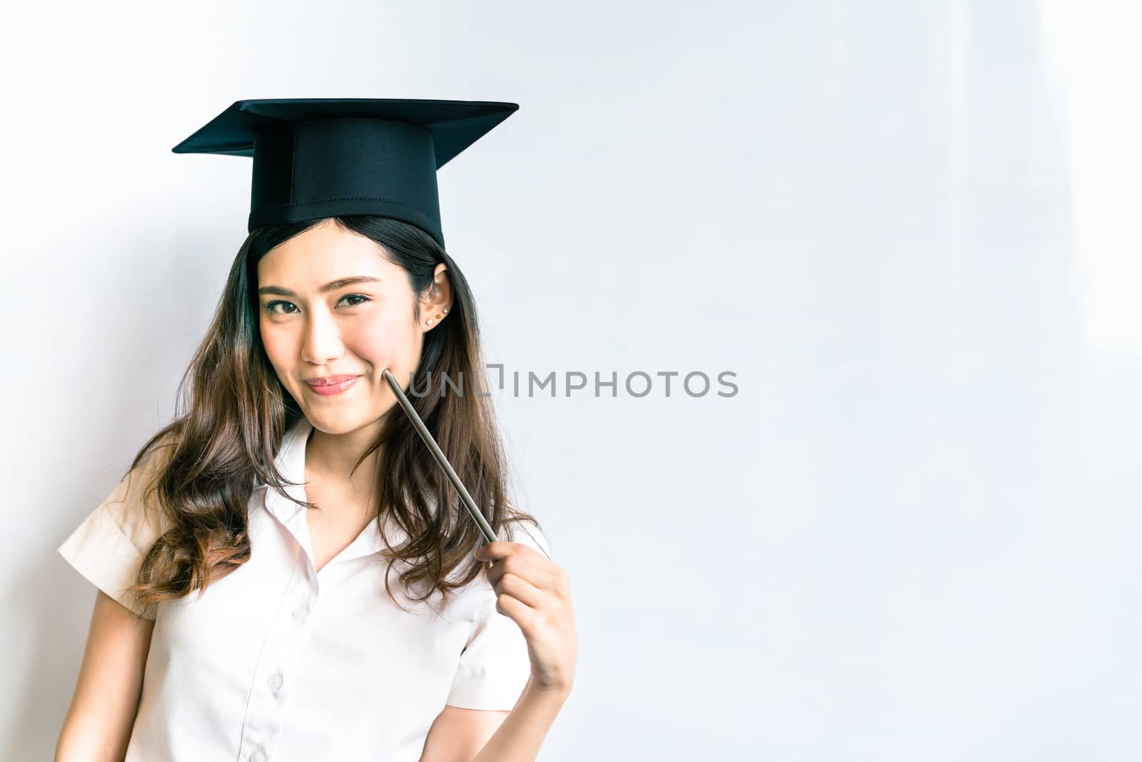 Beautiful asian university or college graduate student woman wearing mortar board, doing cute pose in front of shiny whiteboard, with copy space by beer5020