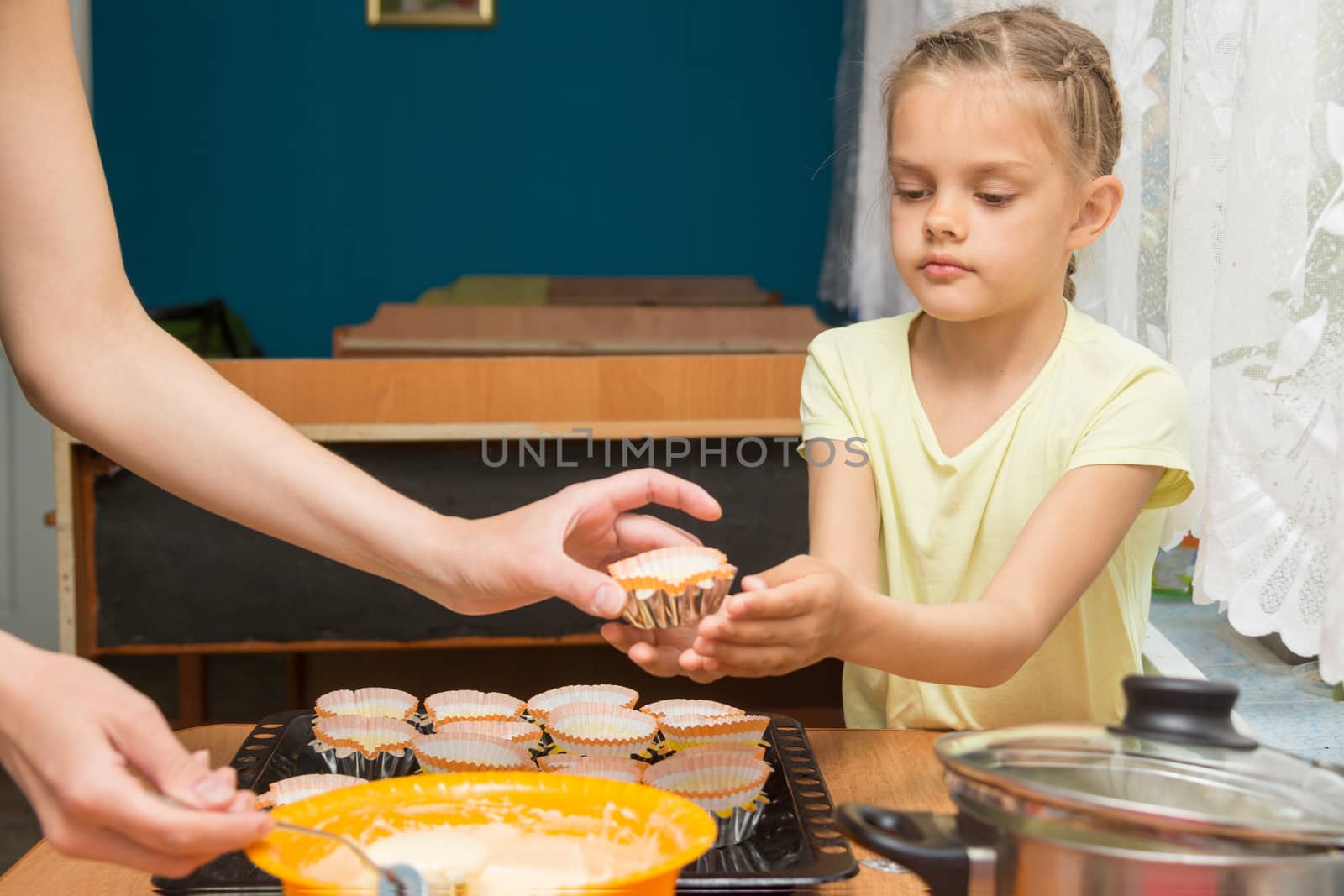 Daughter helps mum to prepare cupcakes for Easter by Madhourse