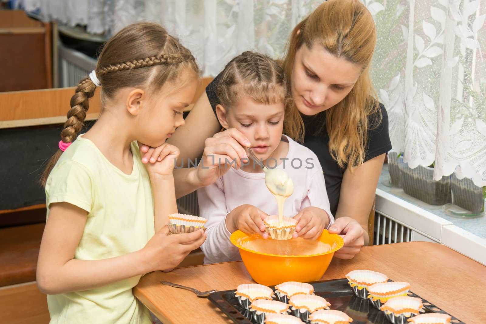 Mom teaches two daughters to cook Easter cupcakes by Madhourse