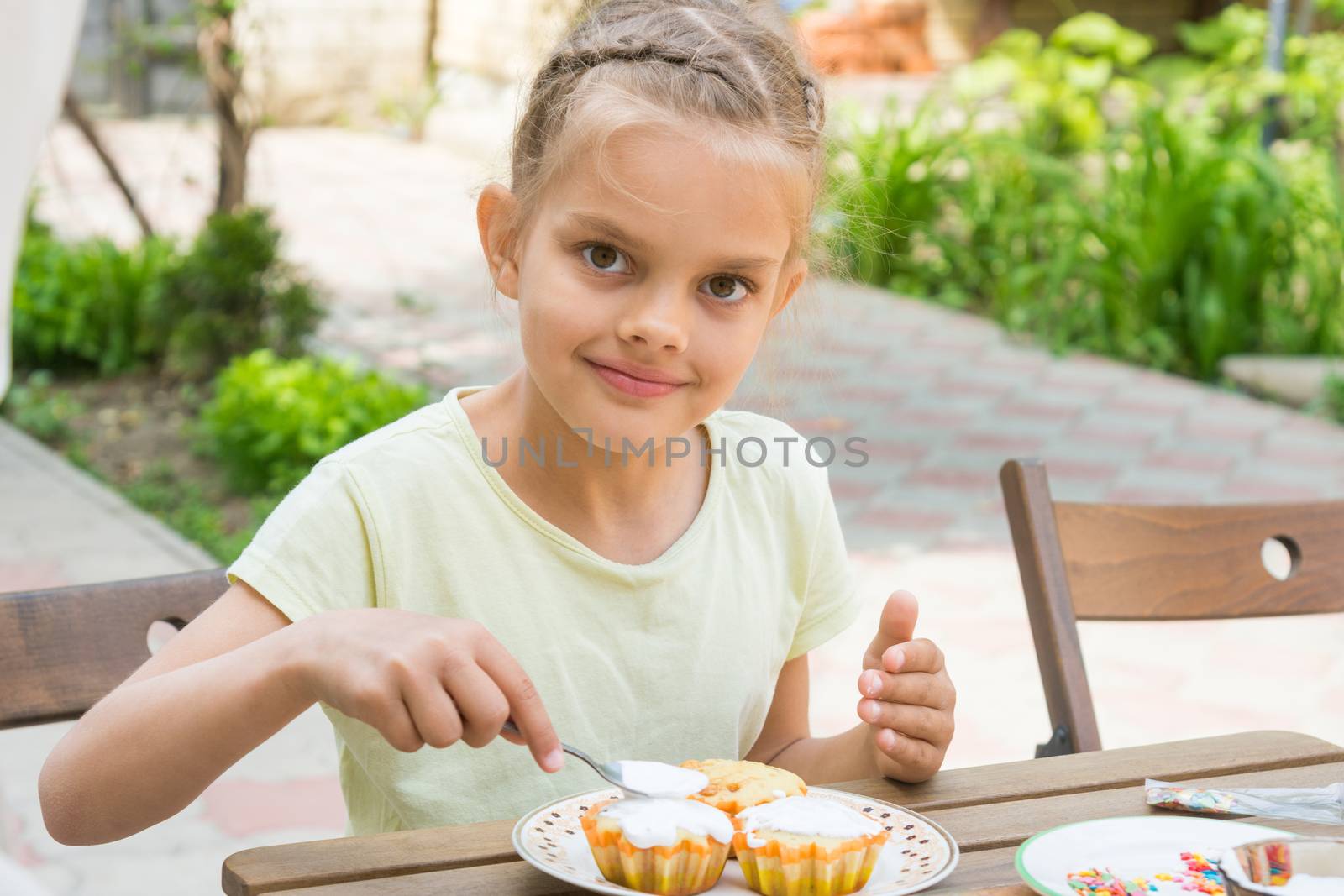 Happy girl coated with confectionery glaze Easter cupcakes