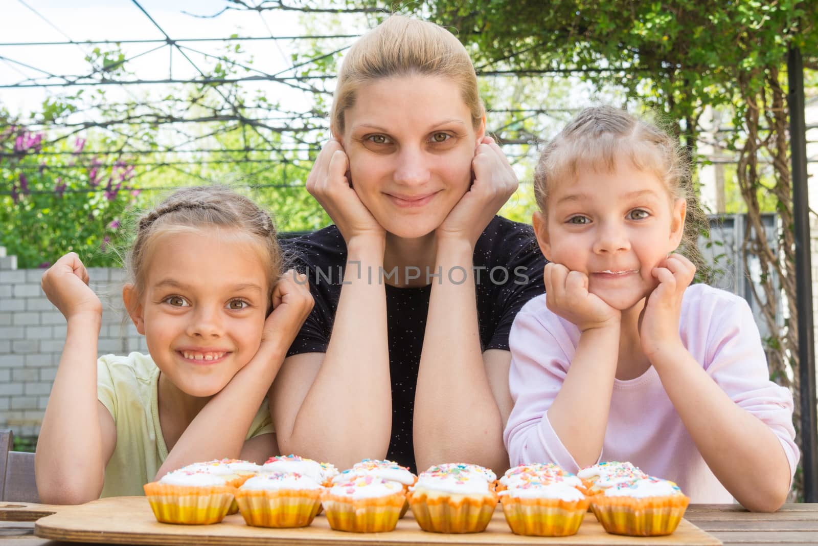 Mother and two daughters have prepared Easter cupcakes