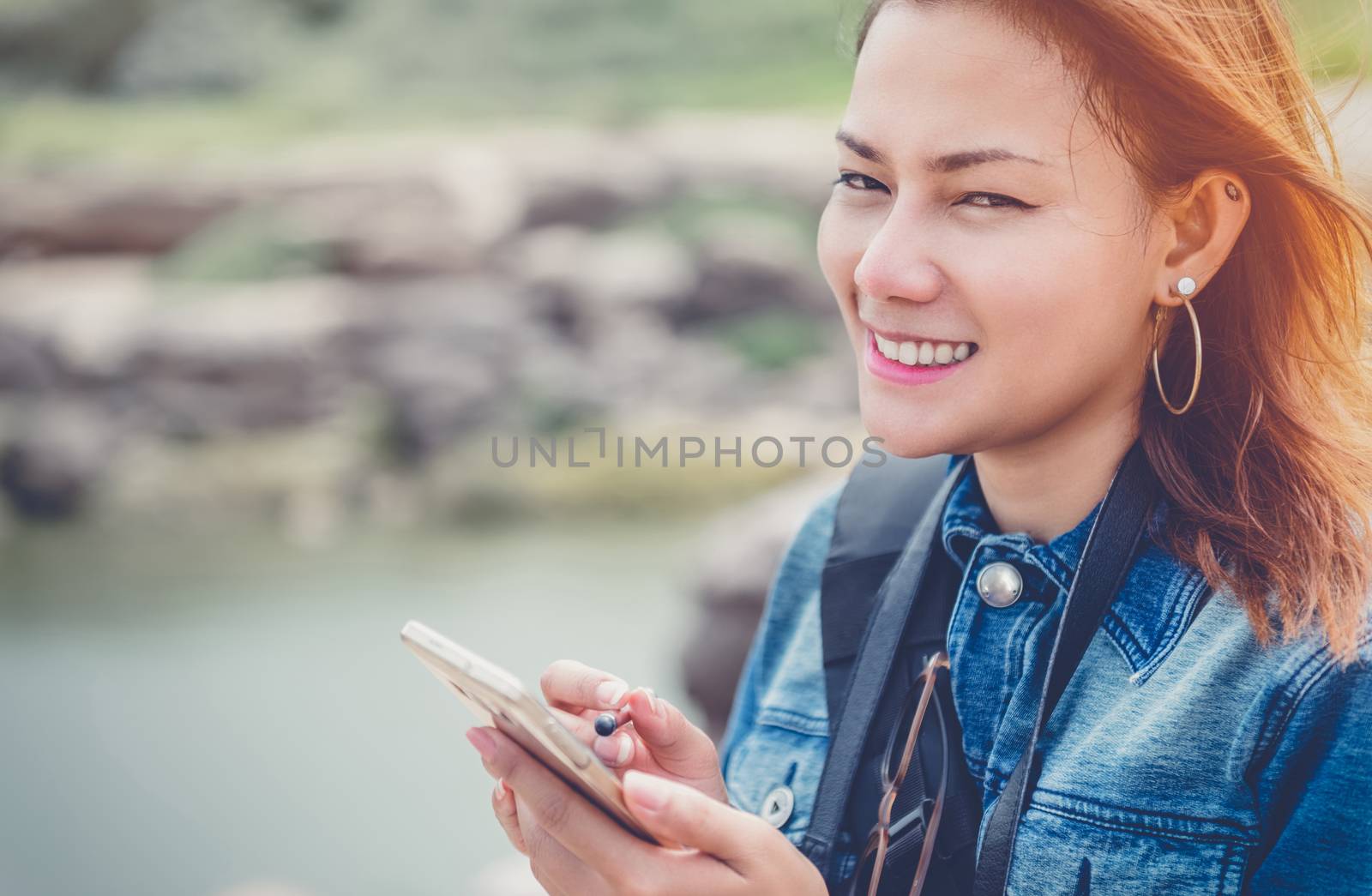 Asia Woman using a cell phone with a smile and good humor.