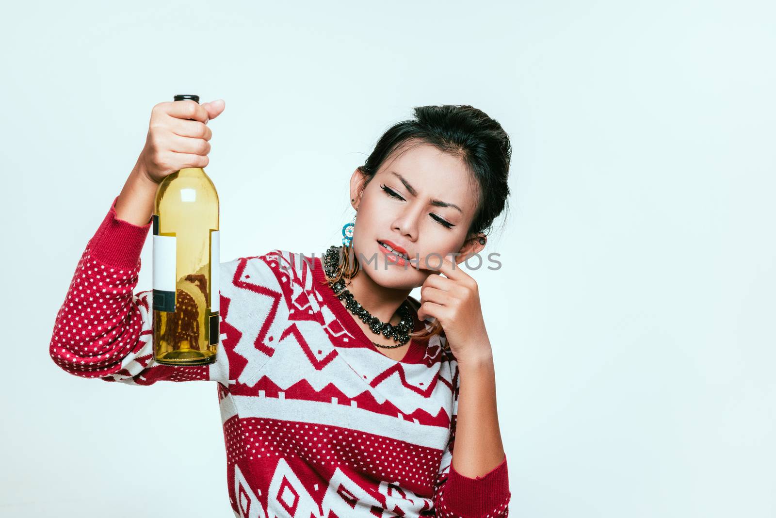 Asian woman holds up an empty bottle, mood wondering.