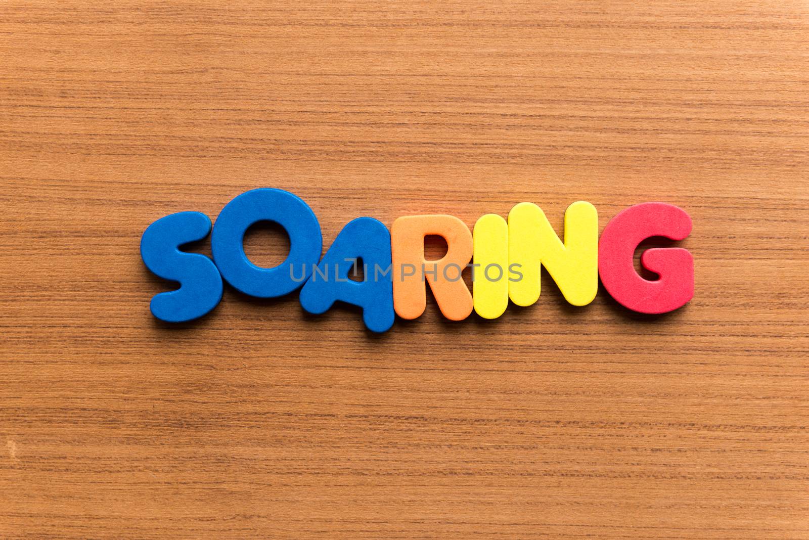 soaring colorful word on the wooden background