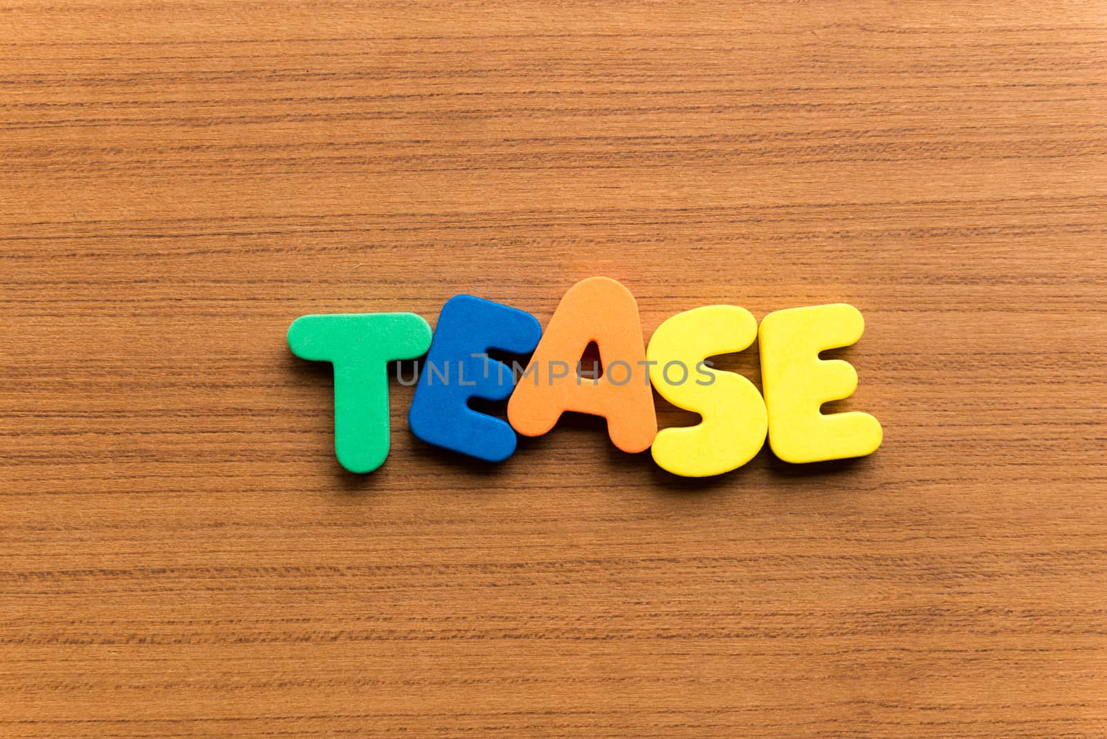 tease colorful word on the wooden background