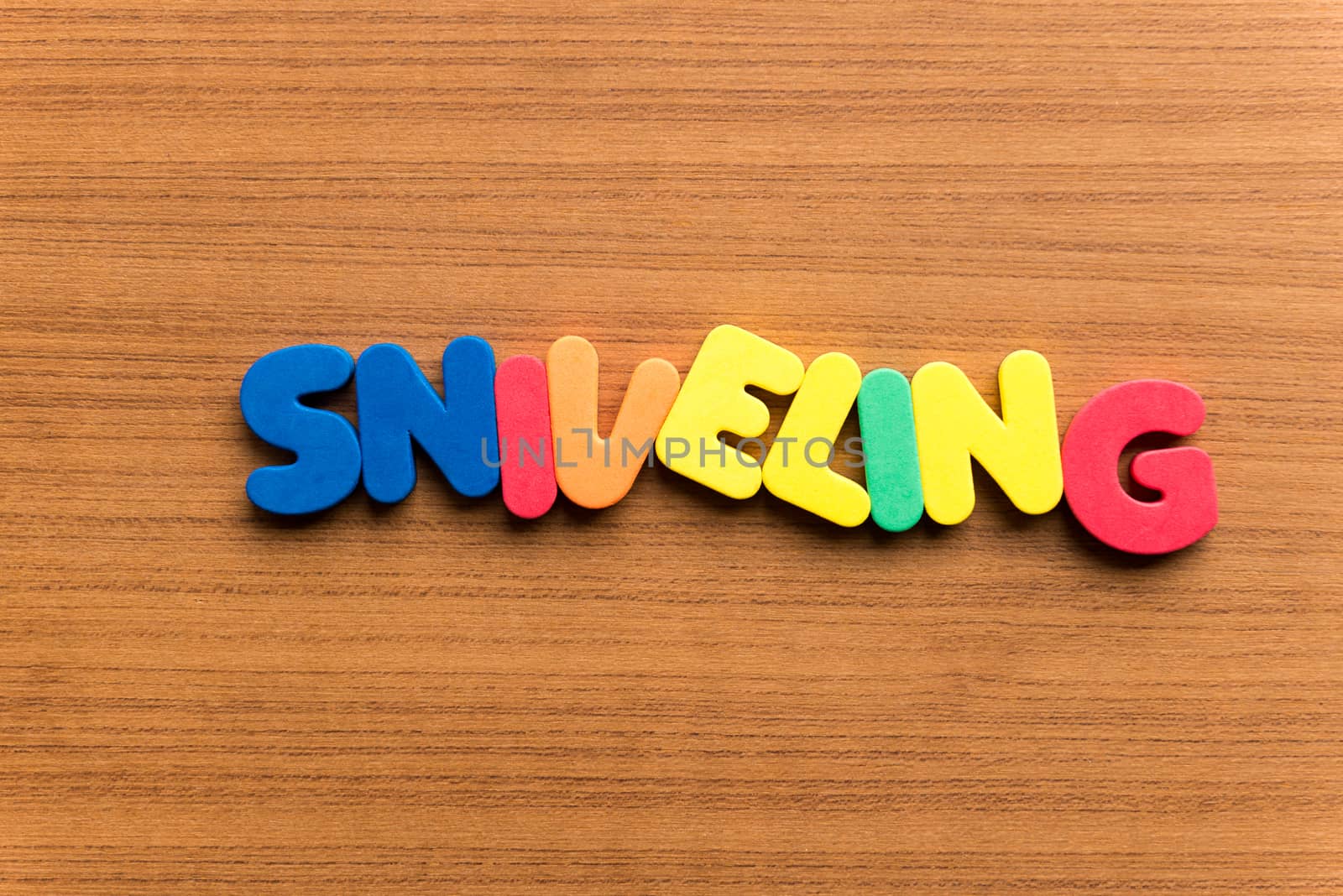 sniveling colorful word on the wooden background