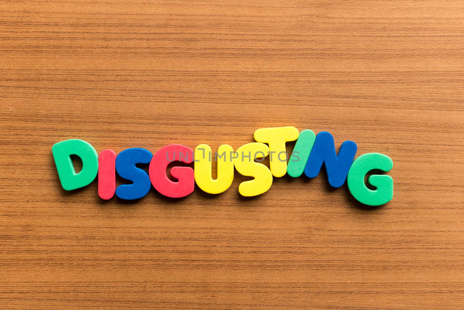 disgusting colorful word on the wooden background