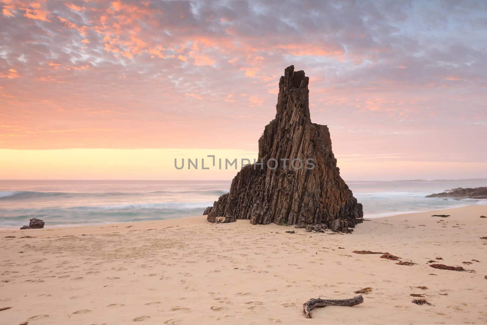 Beach seascape from Meringo, Eurobodalla National park, with magnificent shaped sea stack pointing to that awesome sunrise sky