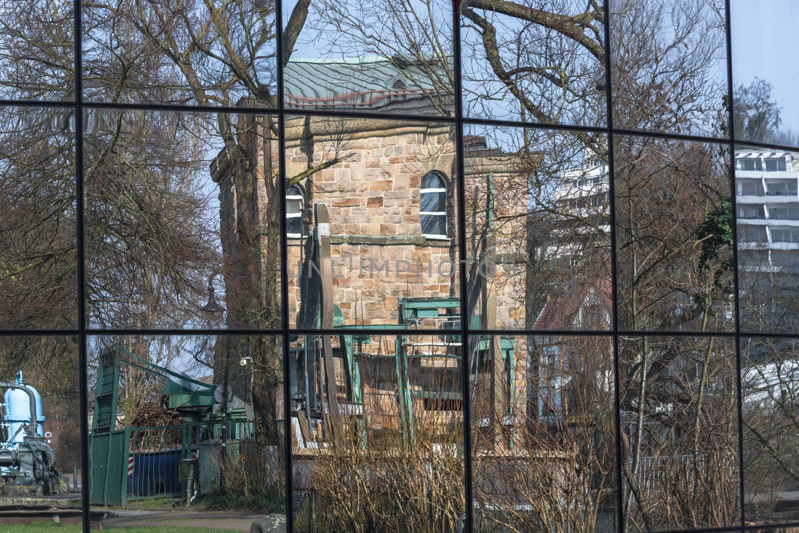 Beautiful glass building facade with reflections of surrounding buildings and nature.