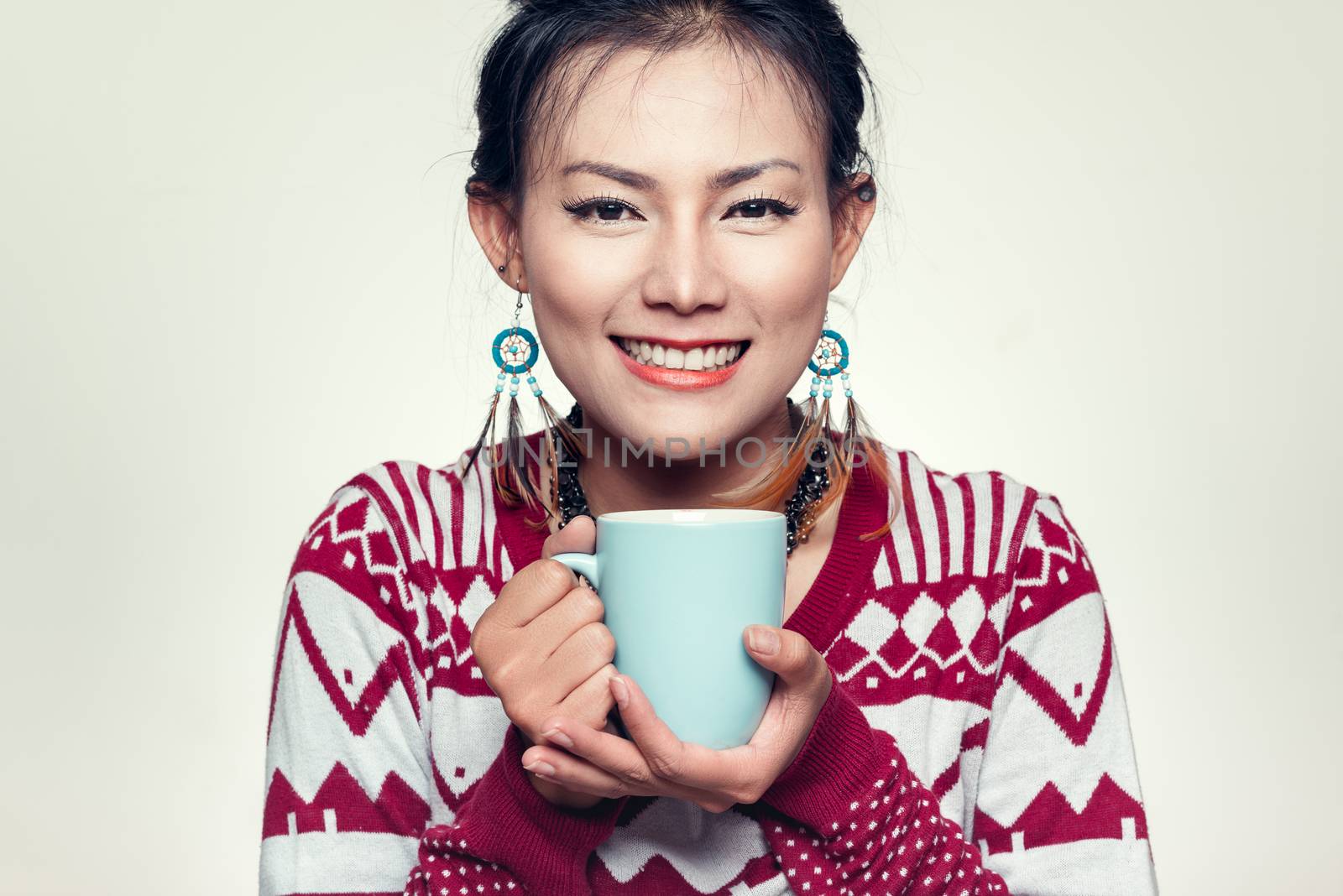 Asian woman smiling with a blue cup by PhairinThee