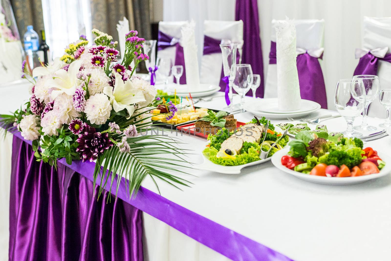 food table decorated with purple and white beautifu flowers for wedding