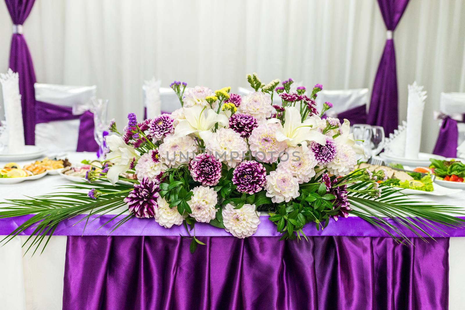 food table decorated with purple and white beautifu flowers for wedding