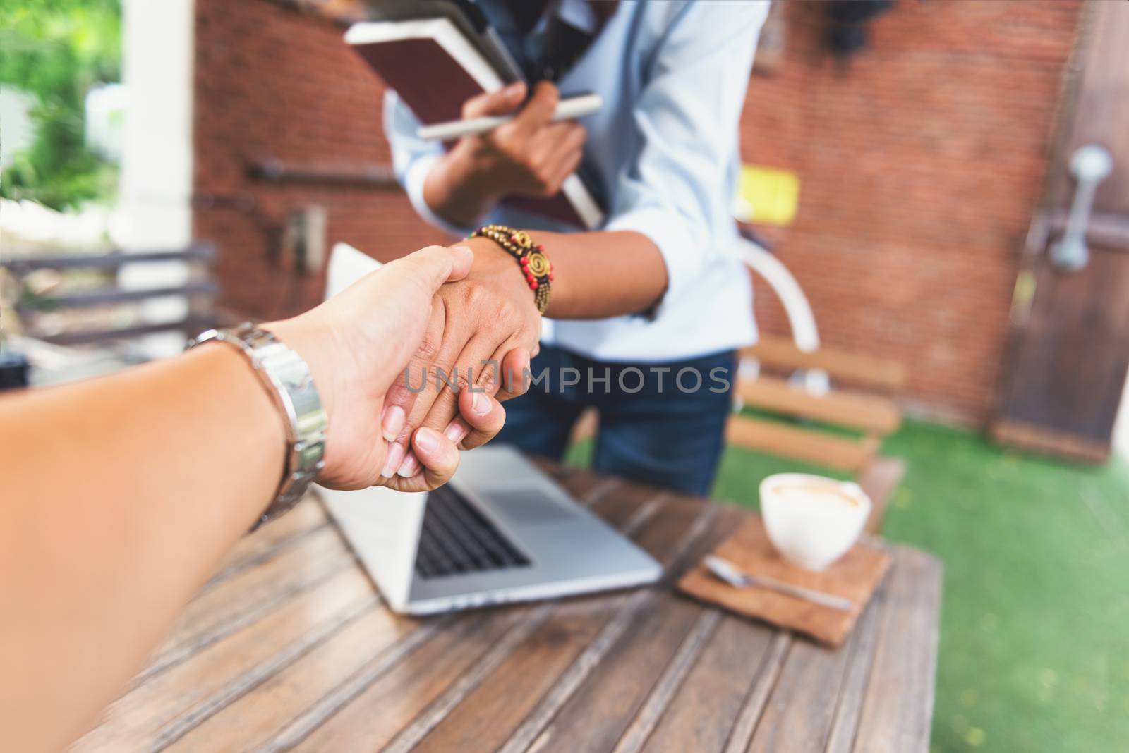 Photos of Asian women who are shaking hands,Focus on hand by PhairinThee