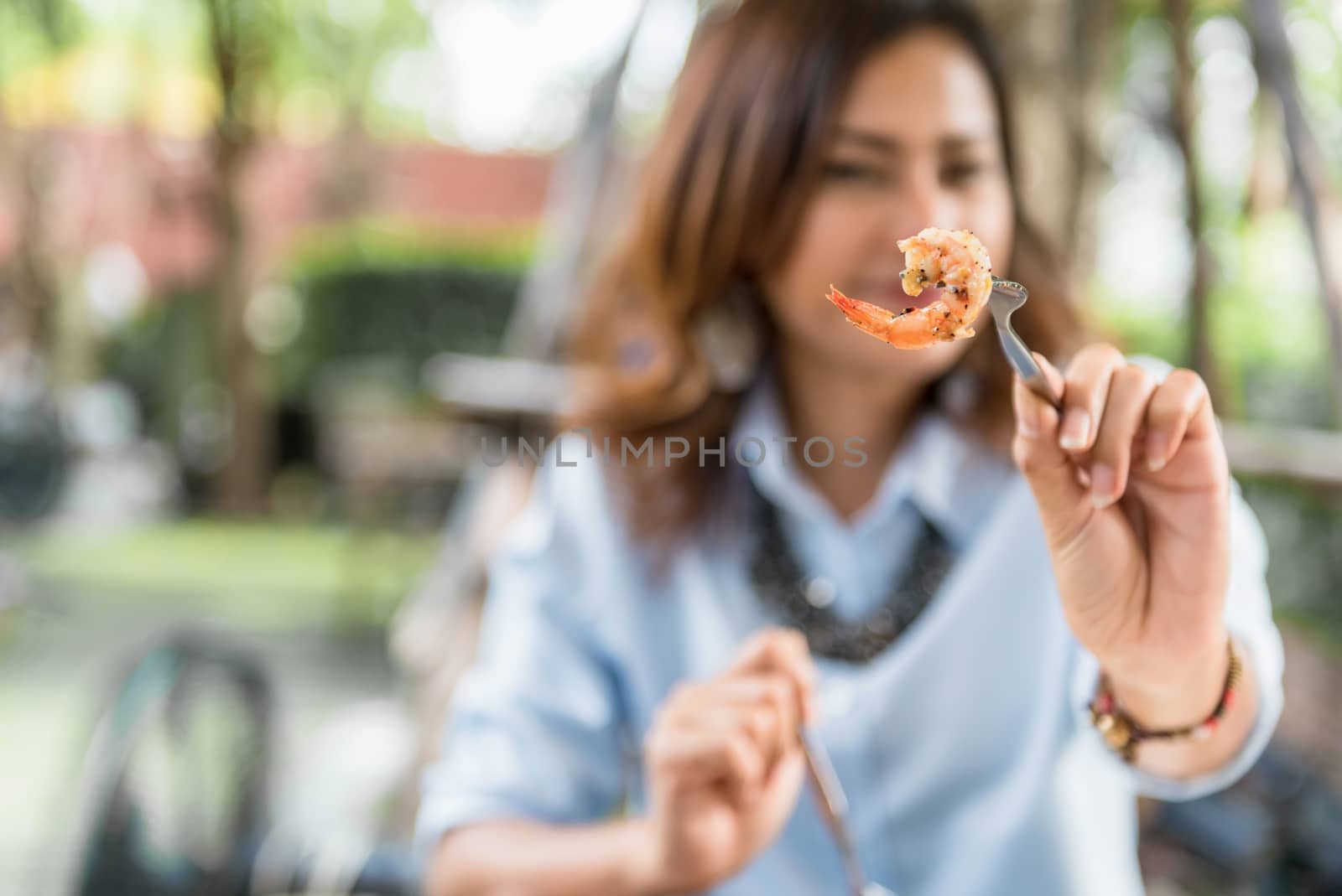 Asian women eating delicious,Focus on shrimp by PhairinThee