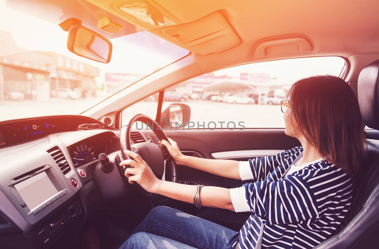 Asian woman driving a car in a happy mood,focus on hand