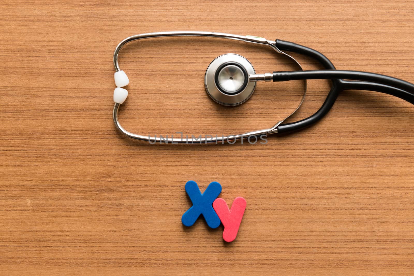 xy colorful word with stethoscope on wooden background