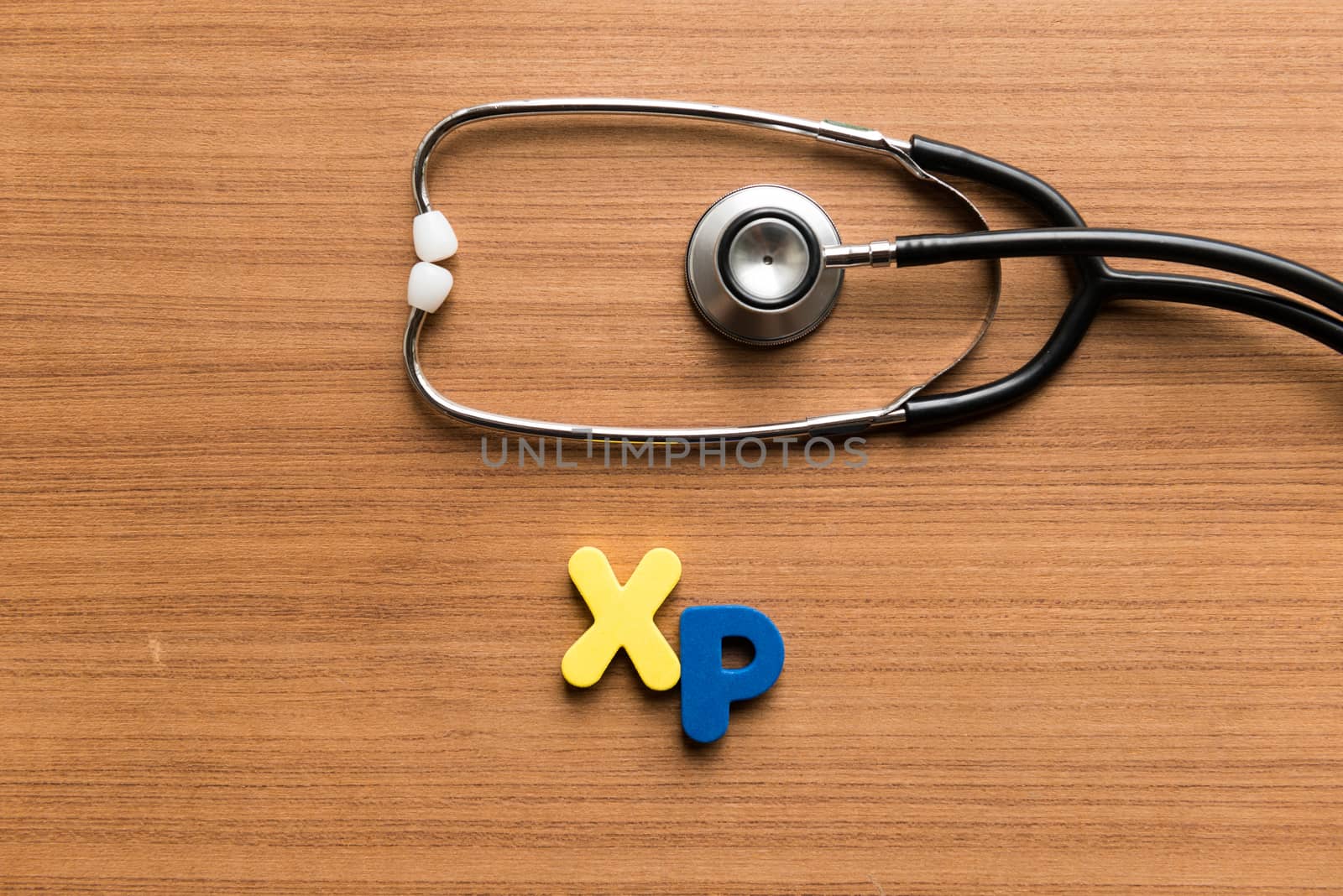 xp colorful word with stethoscope on wooden background