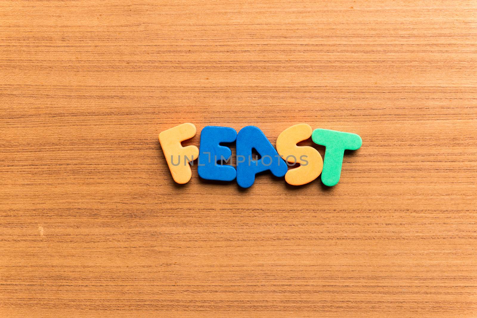 feast colorful word on the wooden background