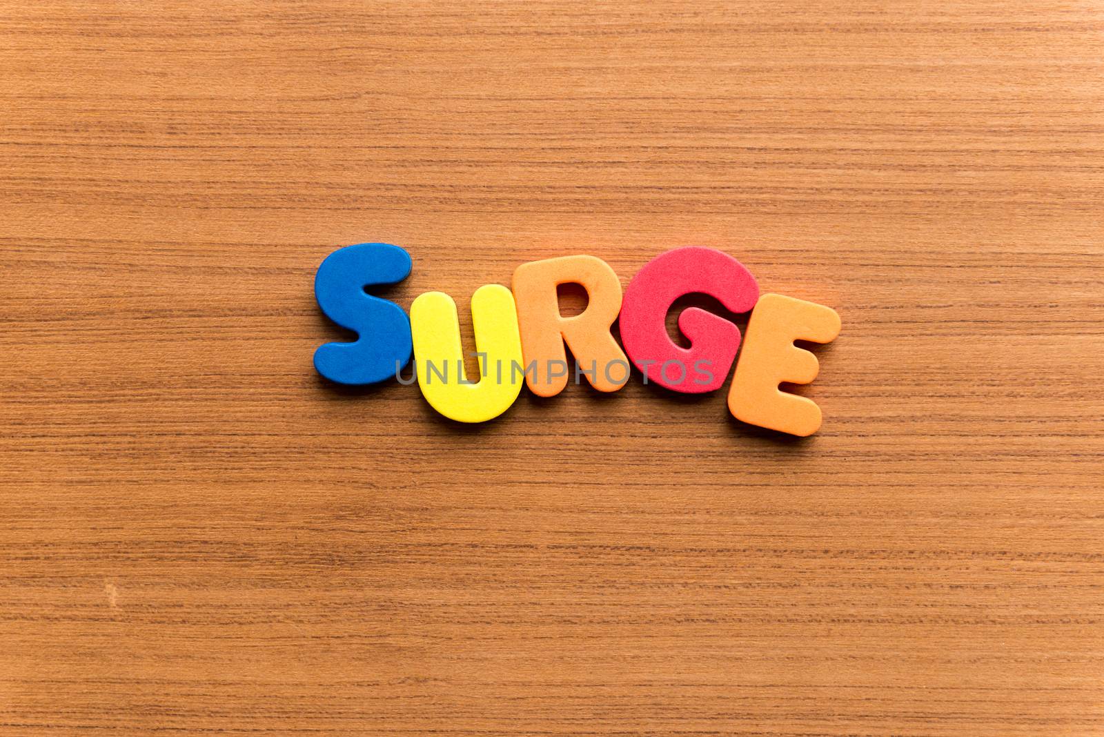 surge colorful word on the wooden background