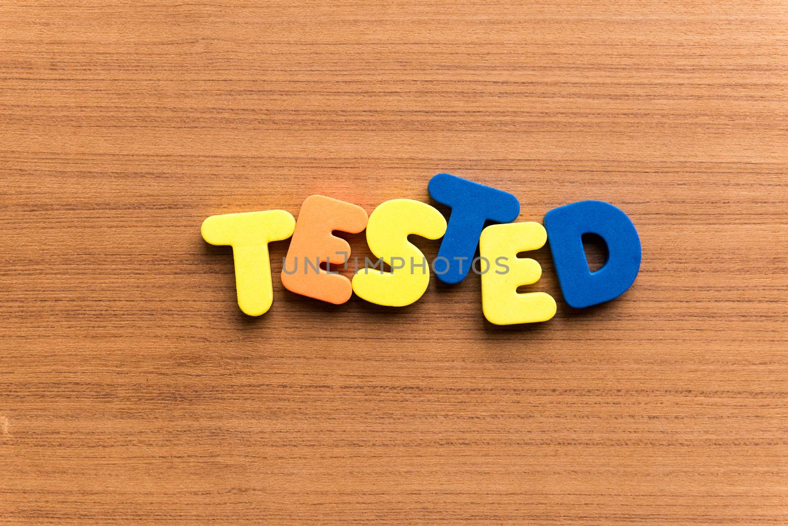 tested colorful word on the wooden background