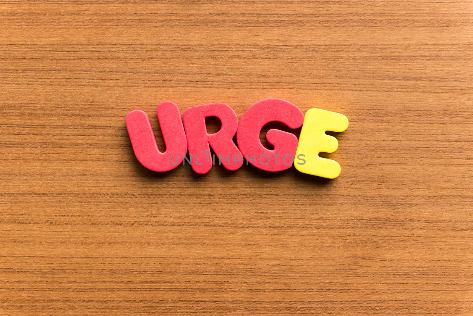 urge colorful word on the wooden background