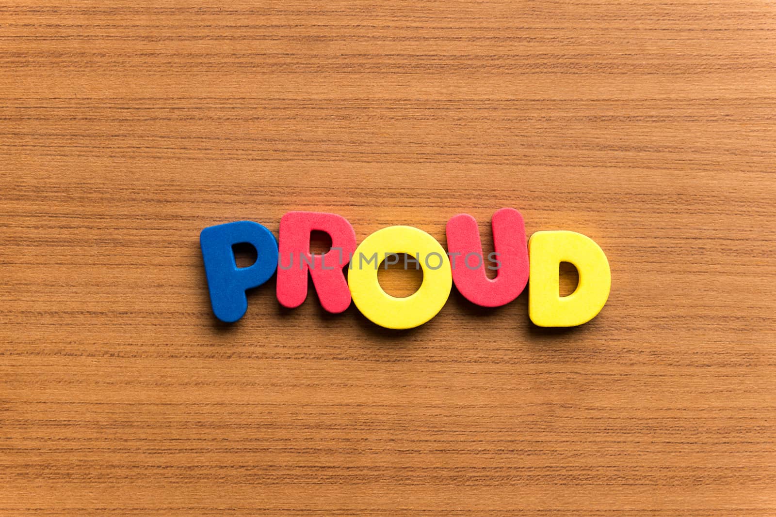 proud colorful word on the wooden background