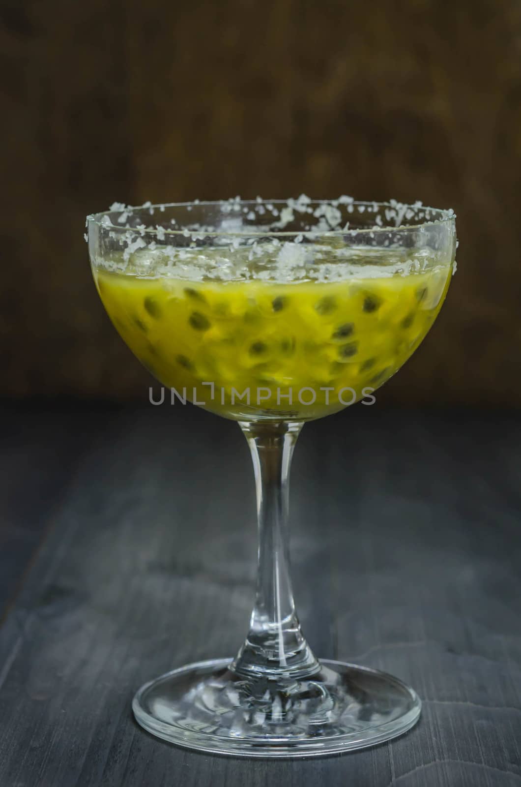 Fresh passion fruit juice in glass over wooden background , still life