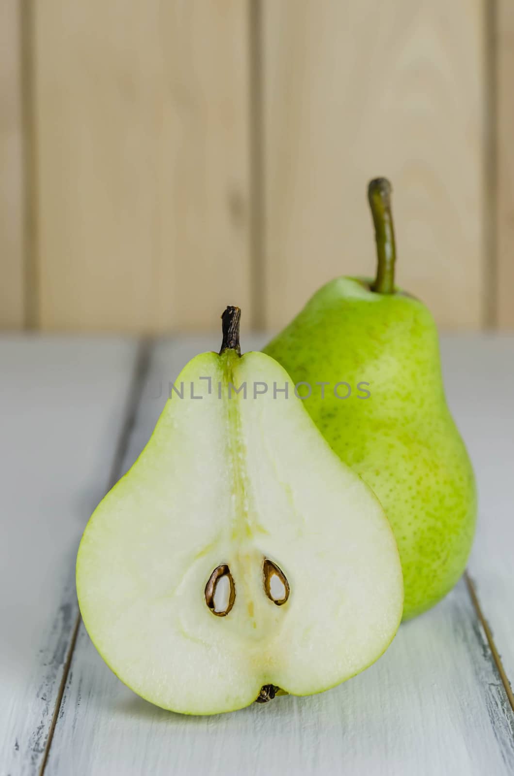 One and a half green pears over white background