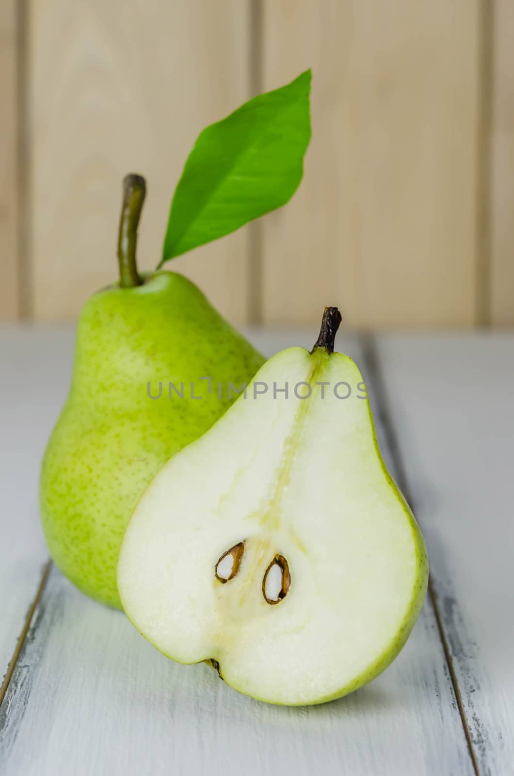 One and a half green pears over white background
