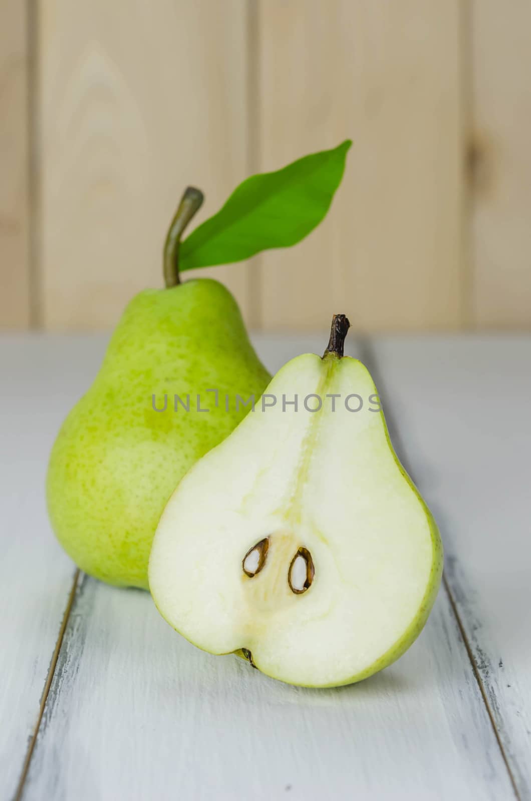 One and a half green pears over white background