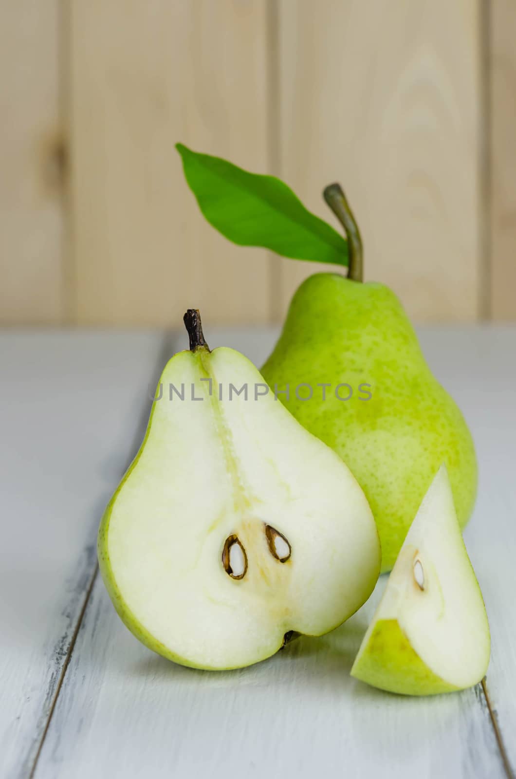 One and a half green pears over white background