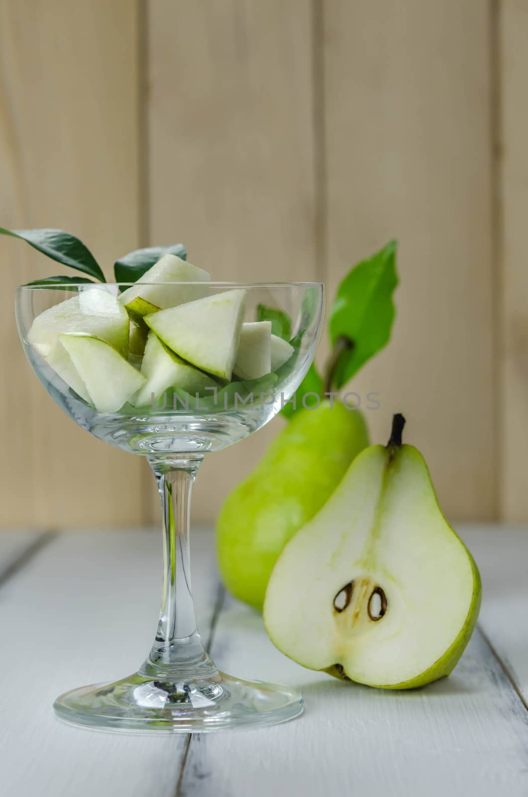 Slice of green pear in glass over white background