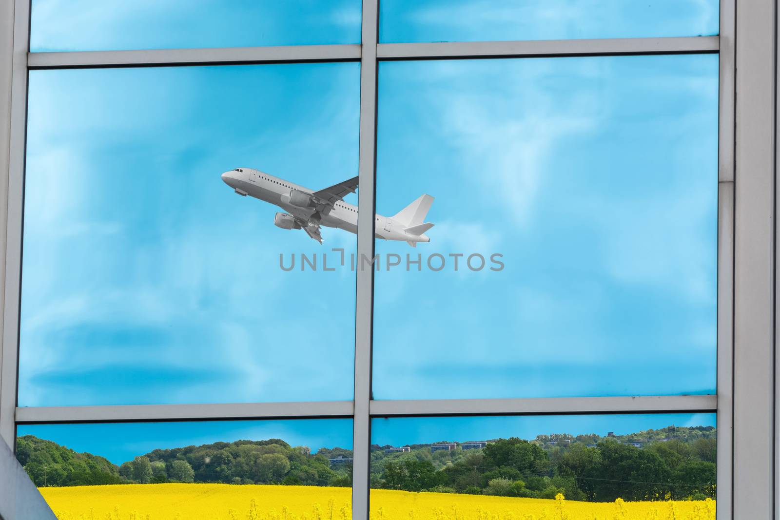 Beautiful glass building facade with reflections of an airplane during startup.