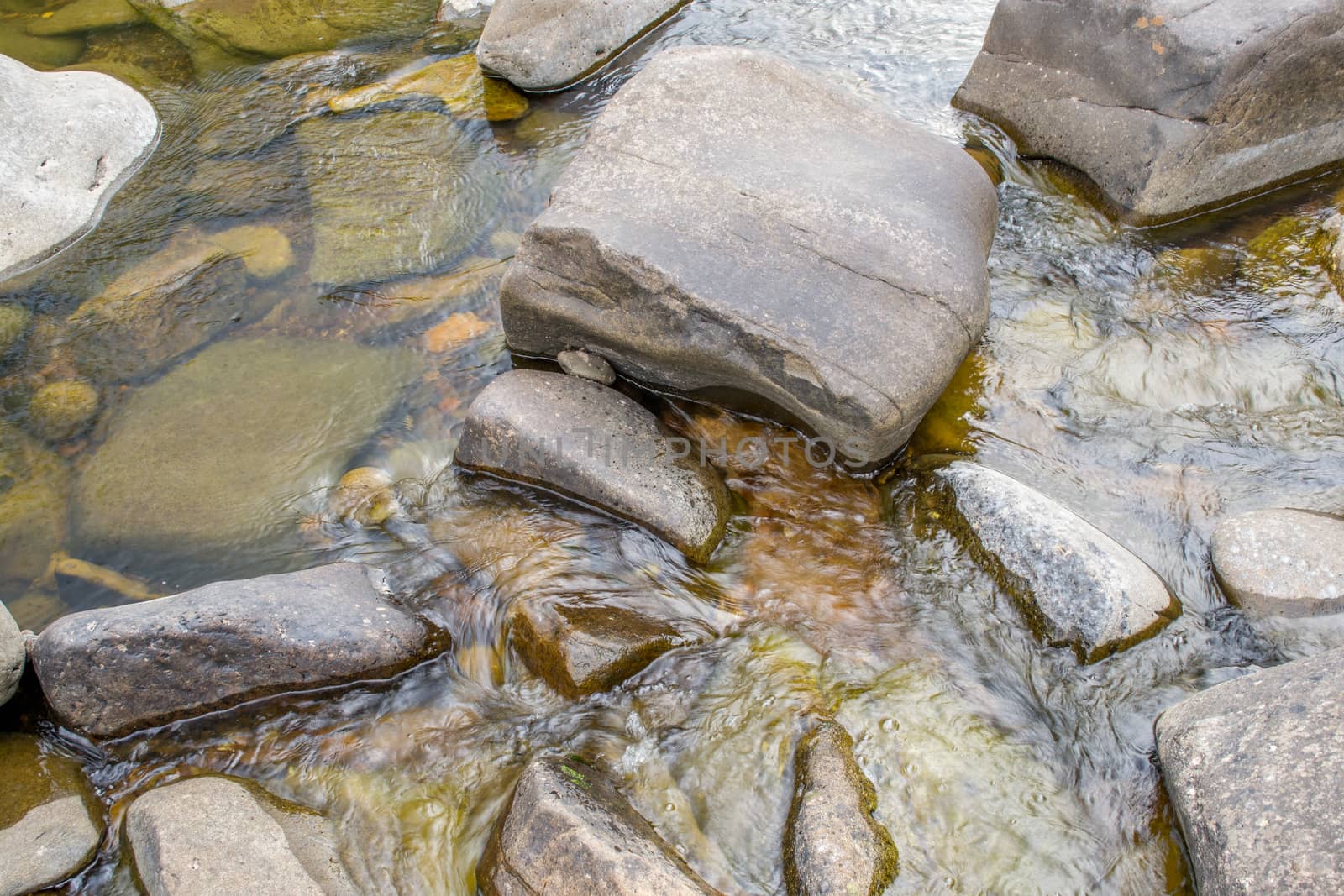 Small rocks in the Mitchell river in Gippsland, Victoria. water flowing around them.