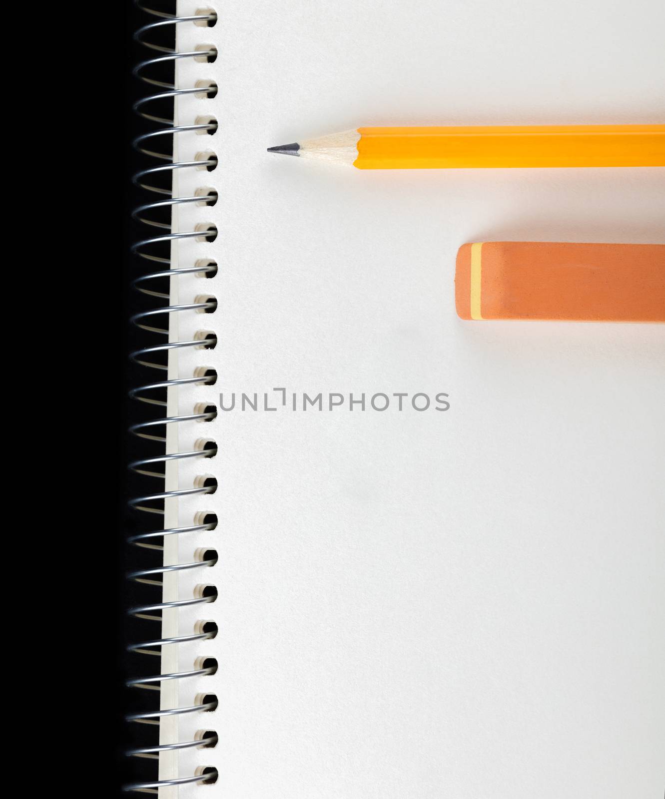 sharpened pencil and eraser laying on notebook