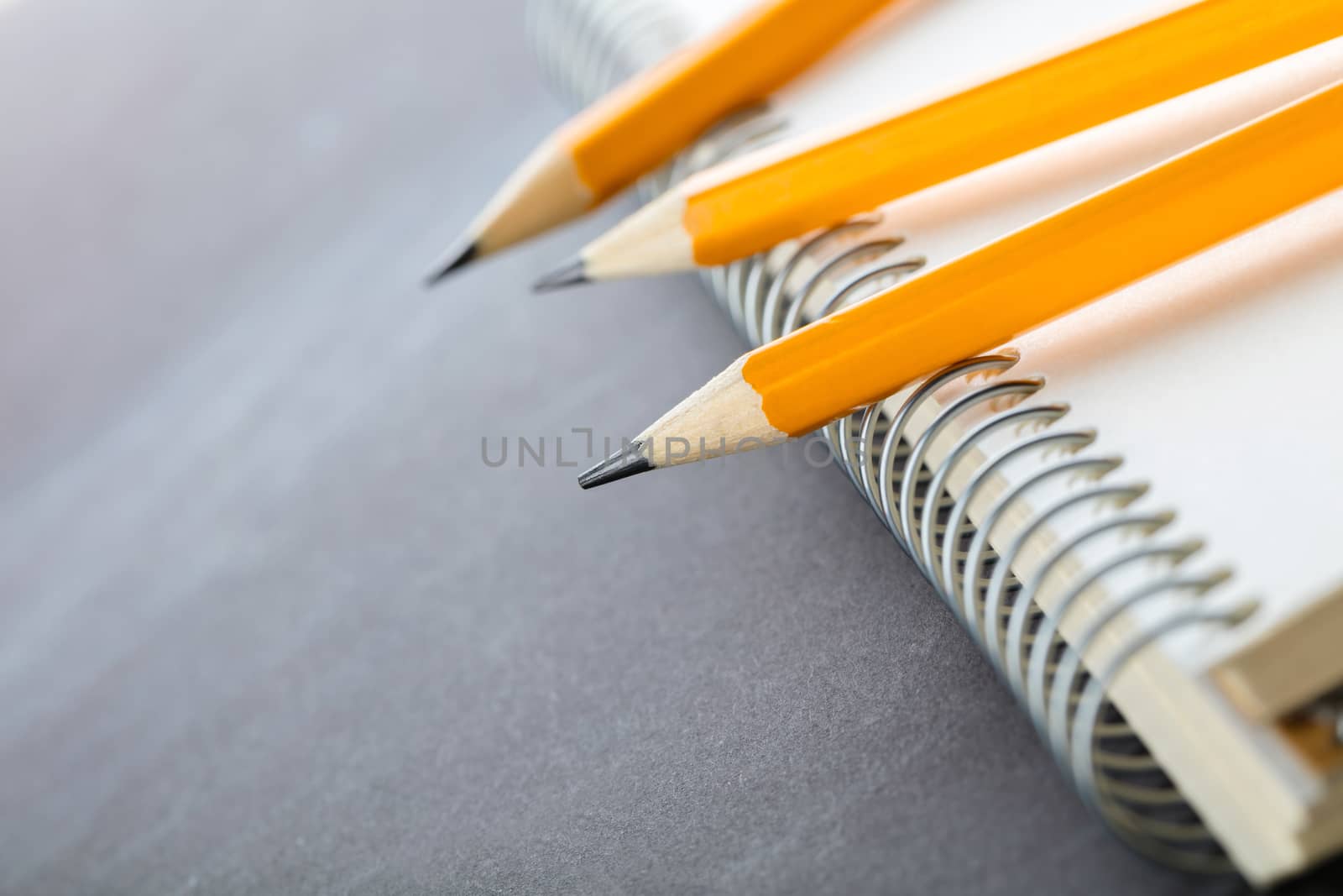 sharpened pencils and a notebook on dark background