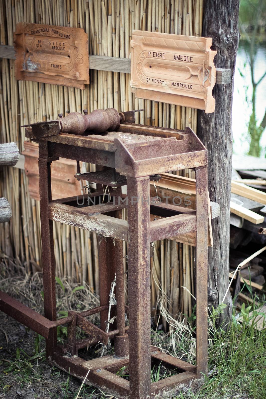 Antique machine for the production of tiles with product samples on the wall