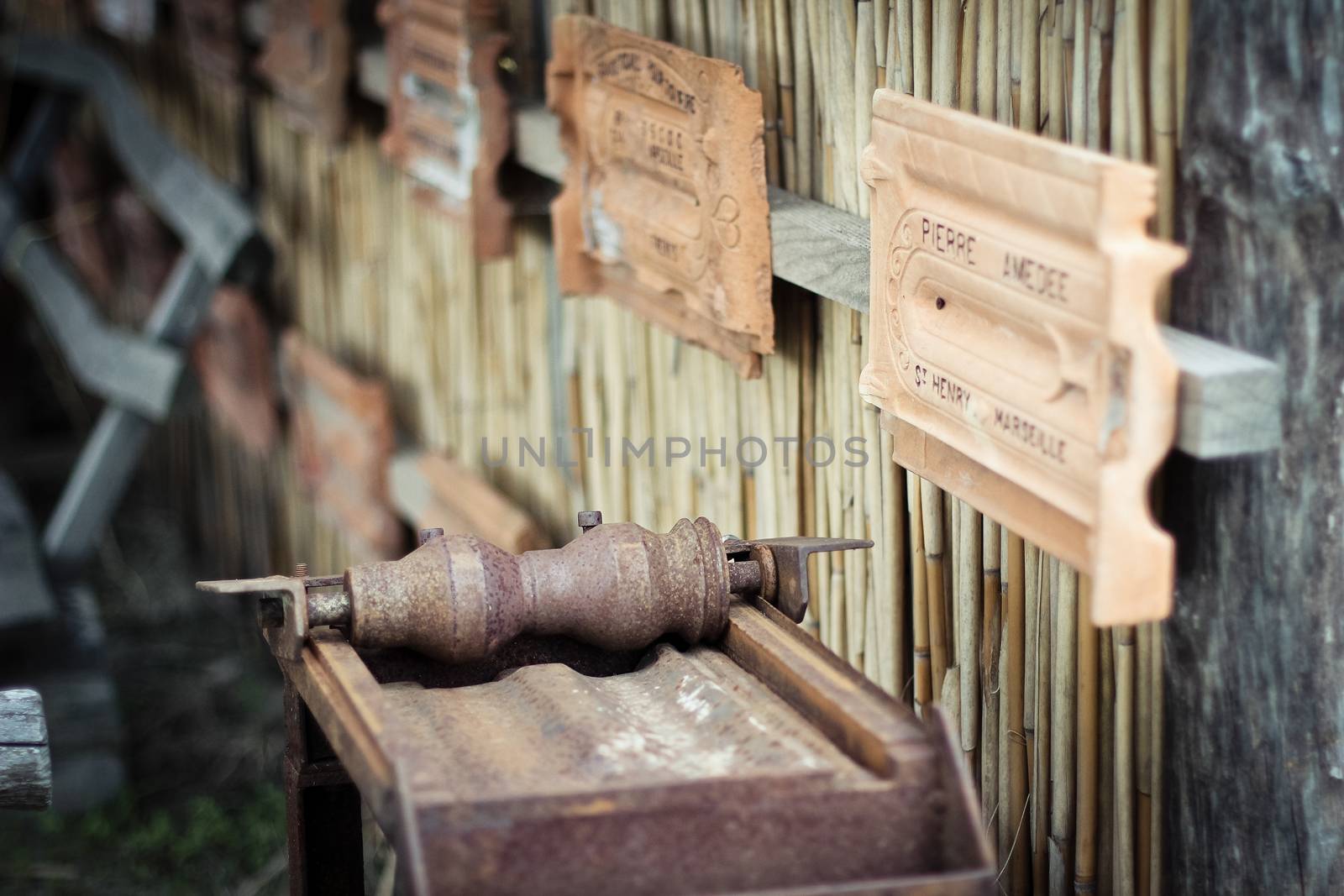 Antique machine for the production of tiles with product samples on the wall