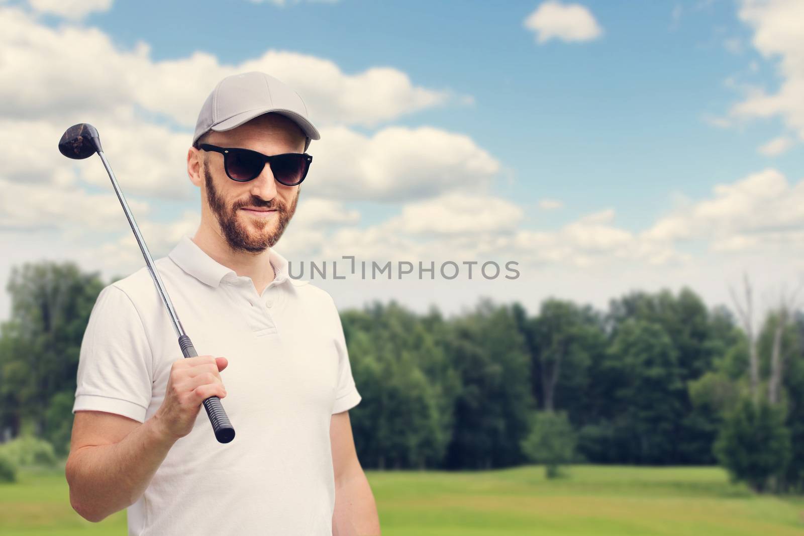 Golfer man posing with golf club at golf course