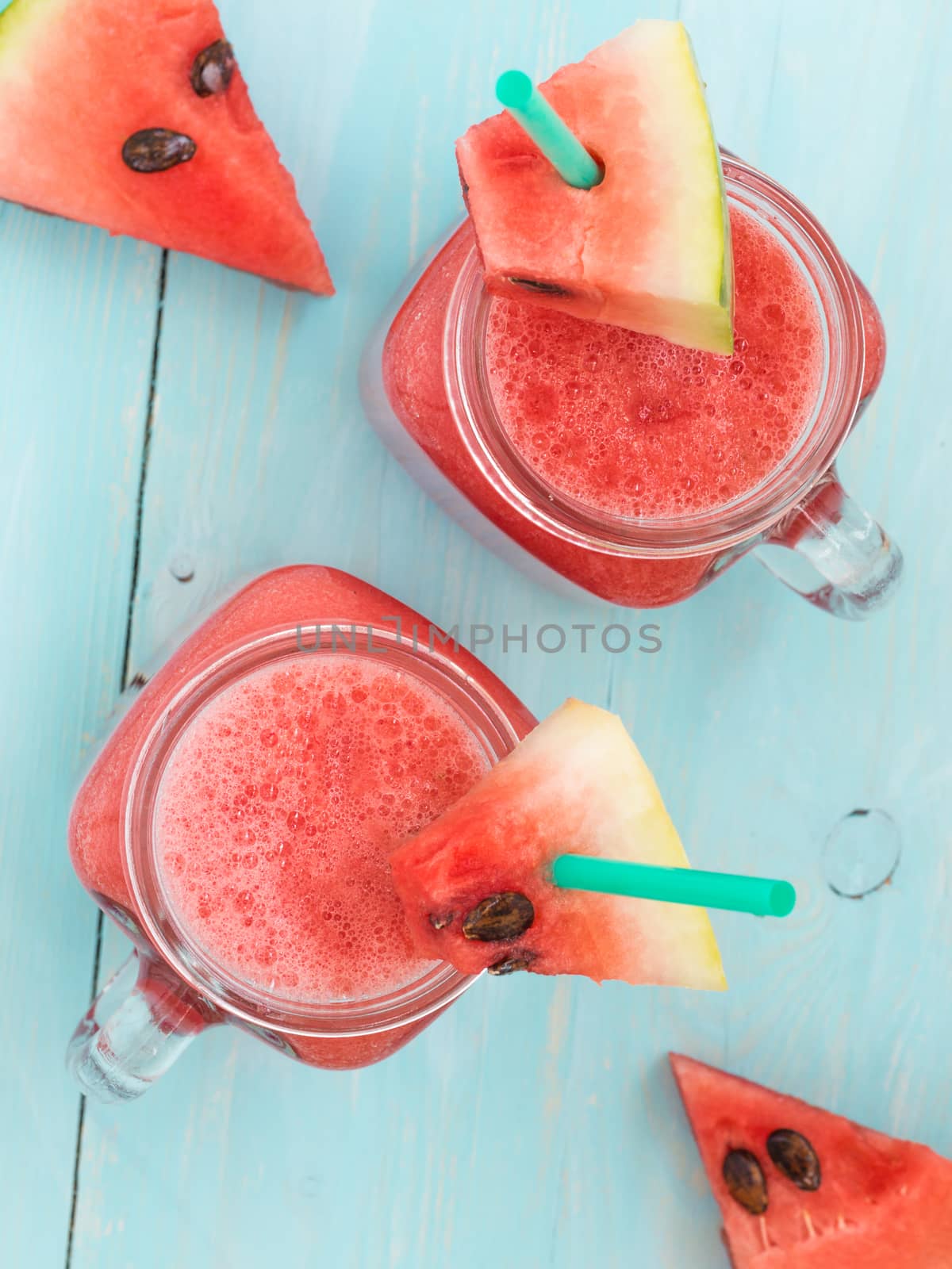 Watermelon smothie and slices on blue background by fascinadora