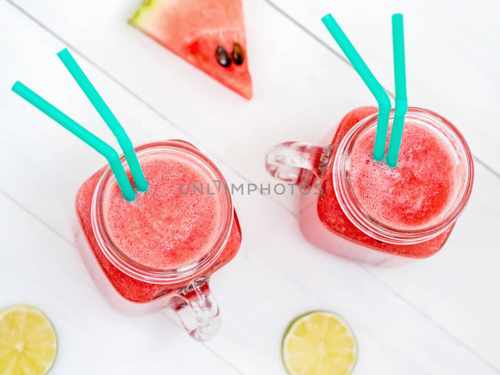 Watermelon smothie and slices on white wooden background. Top view