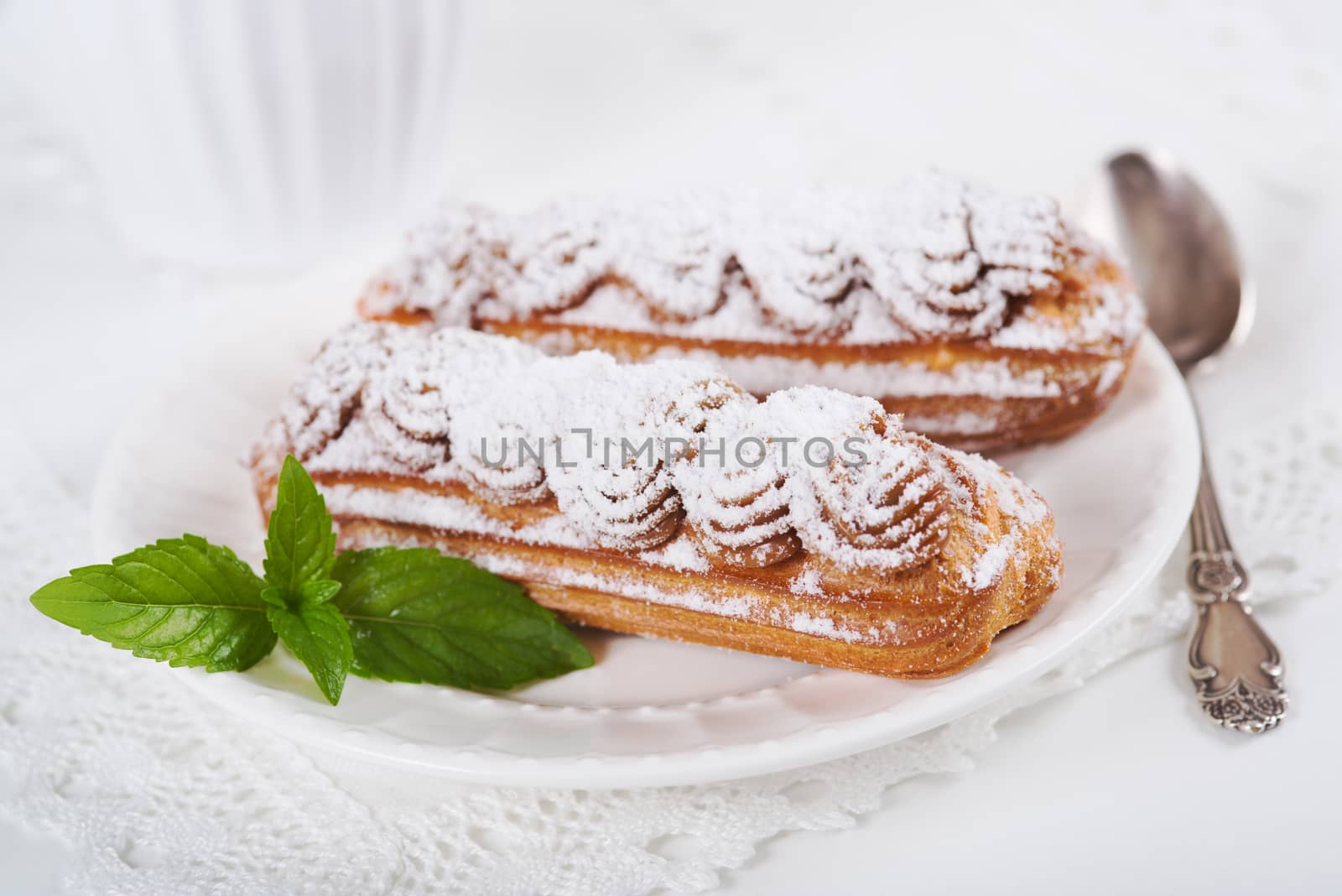 Eclairs on plate on a table on light background