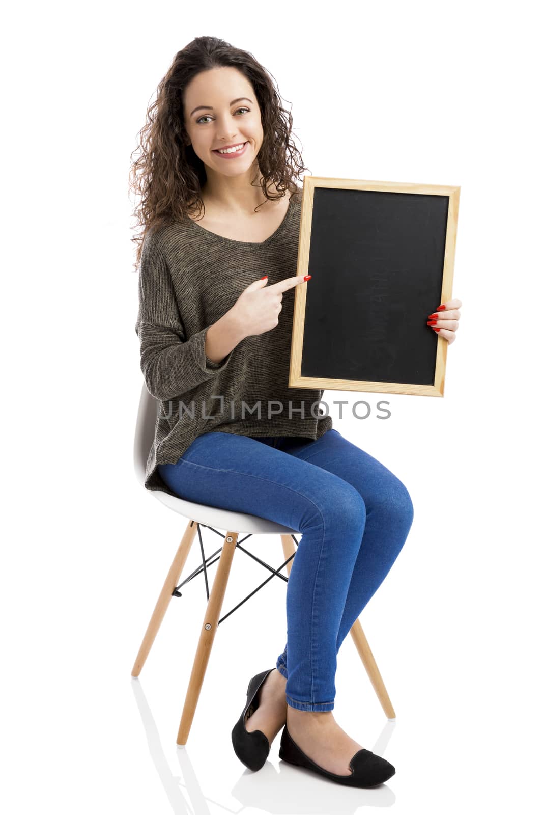 Beautiful and happy woman showing something on a chalkboard