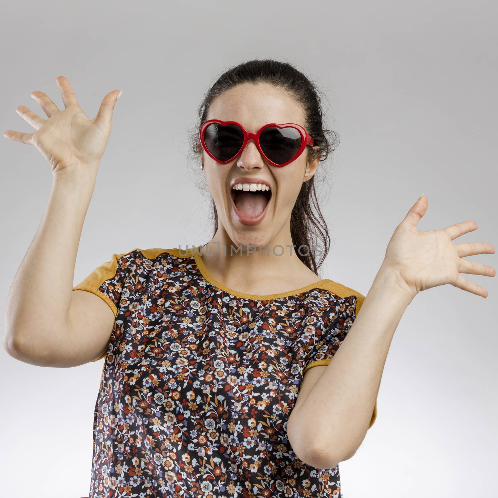 Portrait of a happy woman wearing sunglasses playing and smiling