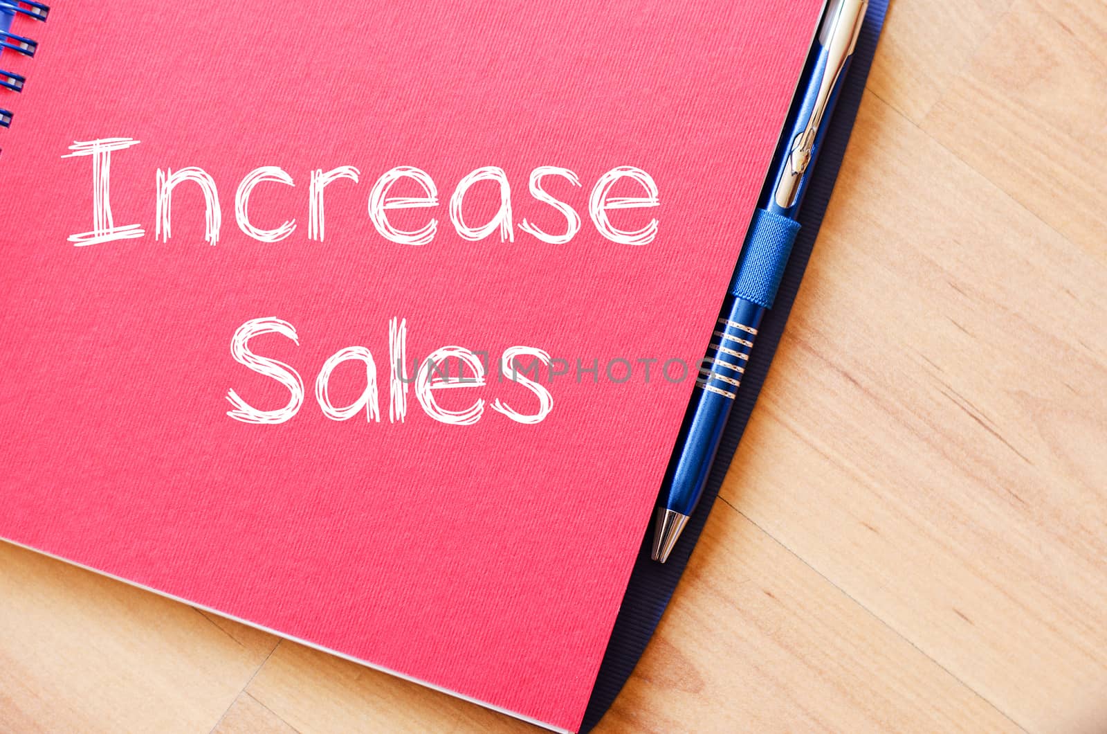 Increase sales text concept write on notebook with pen