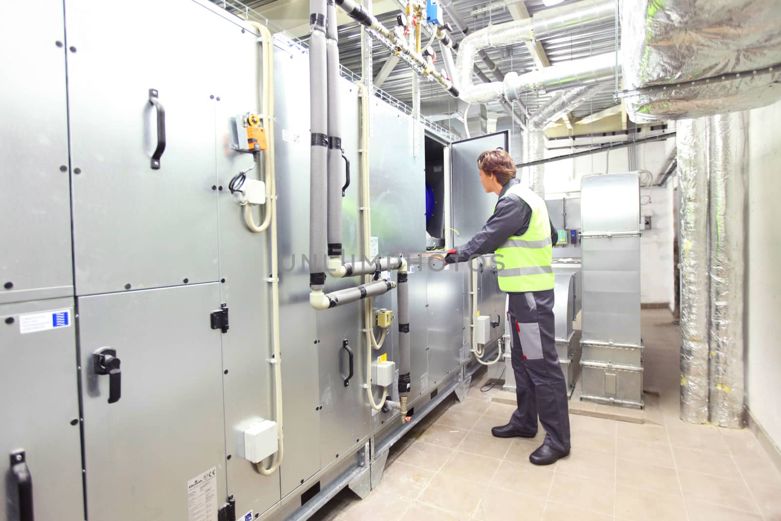 Worker in electrical switchgear room of CNC plant