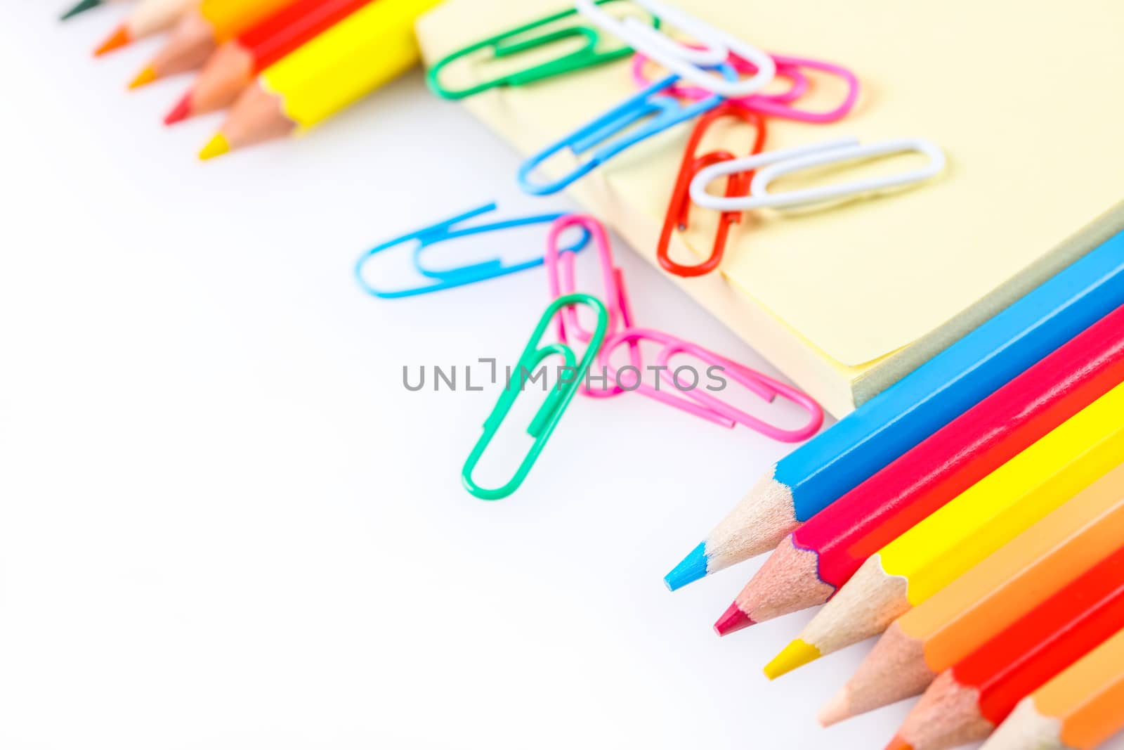 set of colored pencils and paper clips on a white background