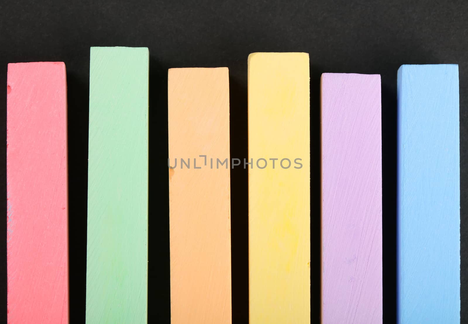 set of colored crayons on a black background