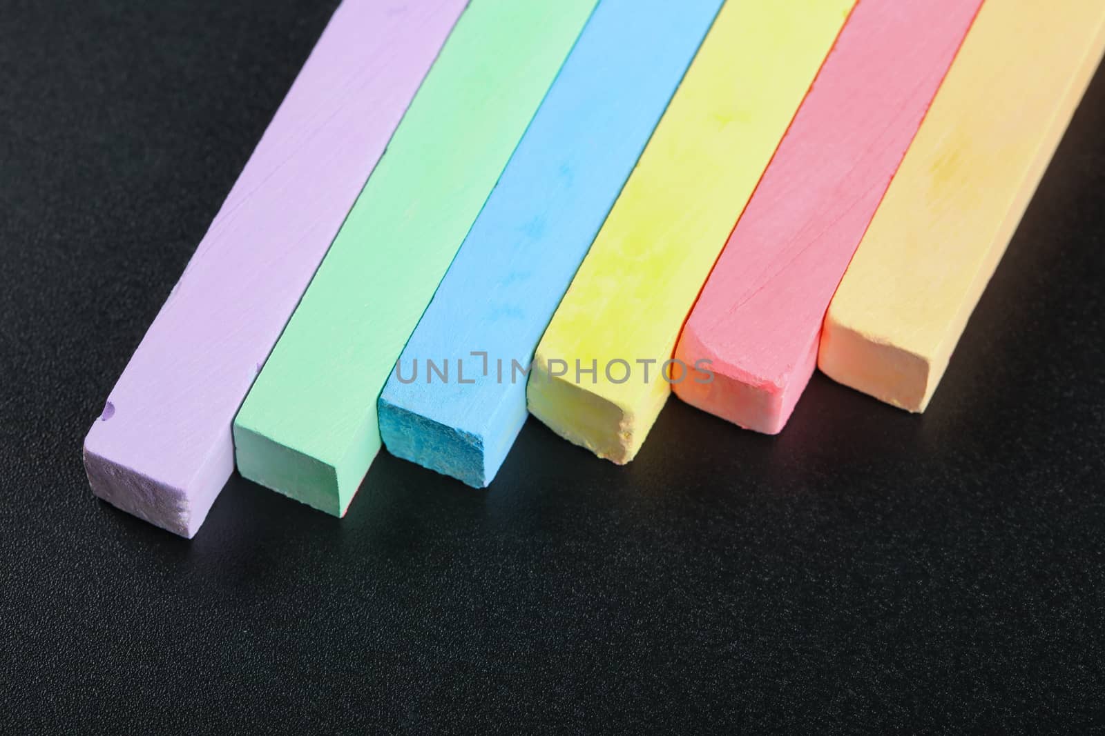 set of colored crayons on a black background